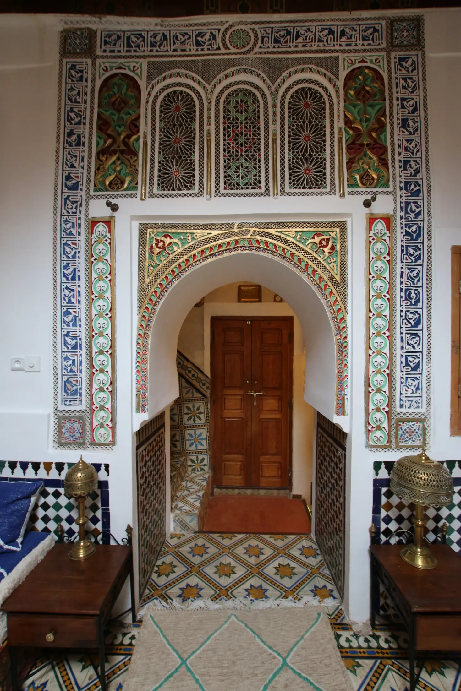 Carved plaster arch and cedar doors at the salon entrance