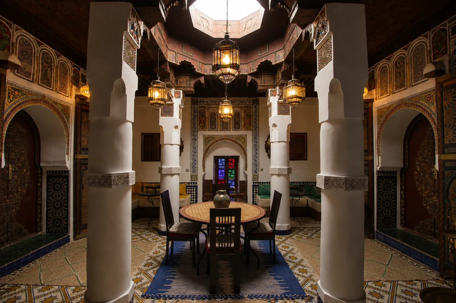 The Grand Salon with white columns, carved arches and lanterns
